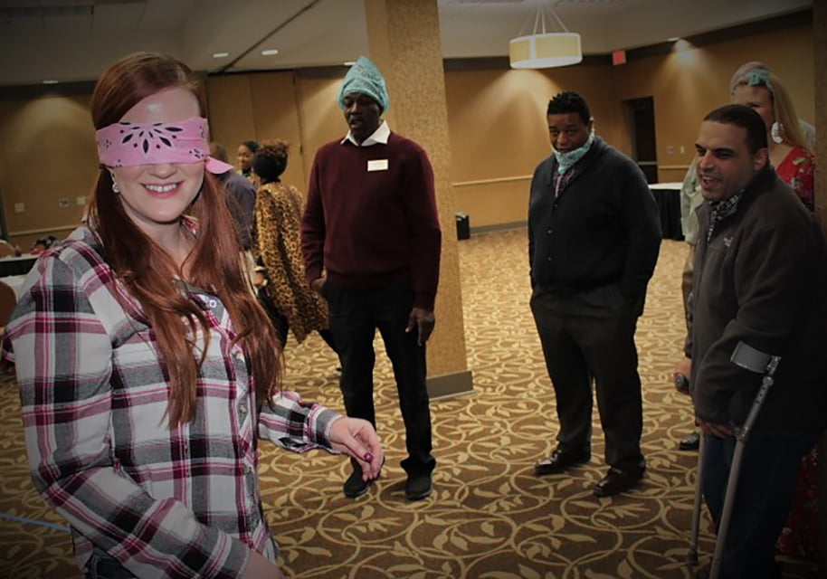 Blindfolded lady participating in training exercise with others.